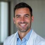 Retrato del Dr. Fernando López, médico sonriente, transmitiendo profesionalidad y empatía.